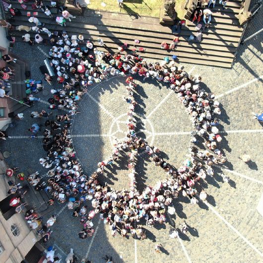 Beim Kinder- und Jugendchortag 2023 des Pueri-Cantores-Verbands bildeten die 400 Teilnehmerinnen und Teilnehmer ein Peace-Zeichen auf dem Stiftsplatz. 