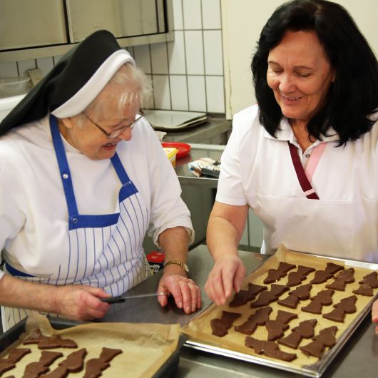 Schwester Arnolda (links) und Monika Breitenbach, Leiterin der Hauswirtschaft kümmern sich um die Lebkuchen-Nikoläuse.