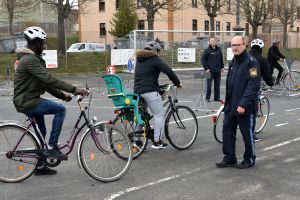 Fahrradtraining für Geflüchtete in der Gemeinschaftsunterkunft: Die Beamten Elmar Heinrich (vorne rechts) und Wolfgang Hartmann (vierter von rechts) von der Polizeiinspektion Würzburg-Stadt geben Einblick in die Straßenverkehrsordnung.