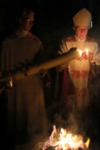 In der Osternacht wird die Osterkerze am Osterfeuer entzündet. Das Foto entstand 2018 und zeigt Weihbischof Ulrich Boom (rechts) und Diakon Dr. Martin Faatz.