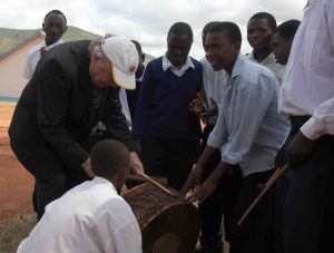Den Menschen im tansanischen Partnerbistum Mbinga war Bischof em. Dr. Paul-Werner Scheele sehr zugewandt. Das Foto zeigt ihn 2011 bei einem Besuch in der Sekundarschule von Kigonsera. Auf Einladung der Schüler versucht er sich als Trommler.
