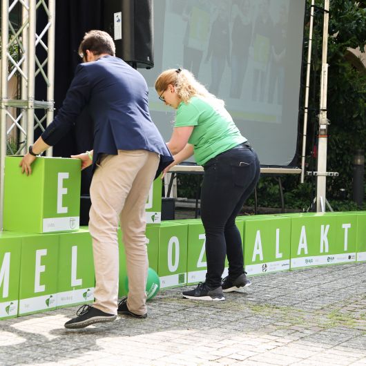 Jeder der grünen Würfel, aus denen BDKJ-Diözesanvorsitzender Sebastian Dietz und viele Helfer eine Mauer bauen, steht für einen BDKJ-Diözesan- oder Jugendverband.