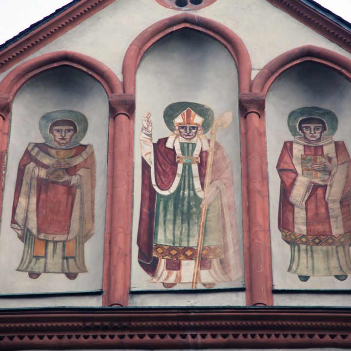 Kilian, Kolonat und Totnan in der Darstellung der dem Kiliansplatz zugewandten Außenmauer der Neumünsterkirche.