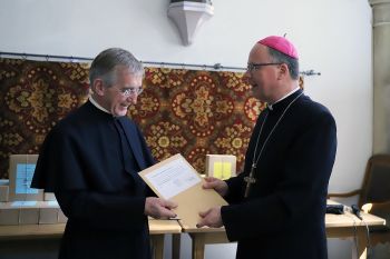 Bischof Dr. Stephan Ackermann (rechts) beauftragt den Postulator des Seligsprechungsverfahrens, Pallottinerpater Heribert Niederschlag, die Dokumente unbeschadet und nach bestem Gewissen nach Rom zu bringen.