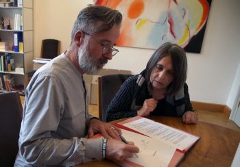 Dr. Jürgen Emmert und Gerda Enk unterschreiben den Schenkungsvertrag.