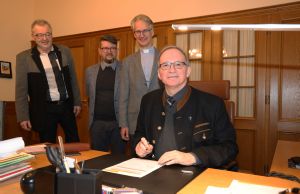 Generalvikar Thomas Keßler (rechts) unterzeichnete den Projektauftrag im Beisein von (von links) Matthias Forstner, Dieter Engelhardt und Diakon Dr. Martin Faatz.