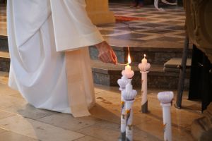 Pfarrer Thomas Menzel entzündet die Kerzen der Kommunionkinder.