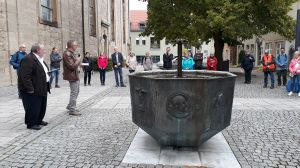 Am Brunnen des Künstlers Wilhelm Uhlig am Alois-Friedrich-Platz: Rudi Reuter und Heinrich Joe Balling (vorne von links) erläutern die Bedeutung der Symbole auf den "Tafeln" rund um den Brunnen.