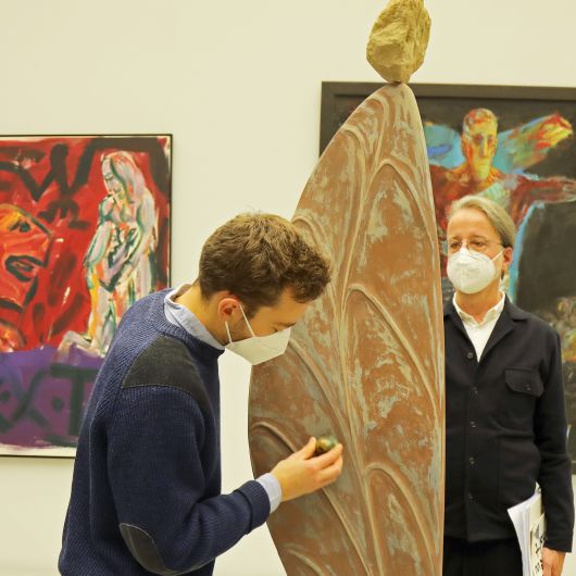 An der Skulptur "Flügel und Stein II" demonstriert Paul Diestel, wie er die Oberfläche seiner Skulpturen poliert. Rechts Dr. Jürgen Emmert, Leiter der Abteilung Kunst.