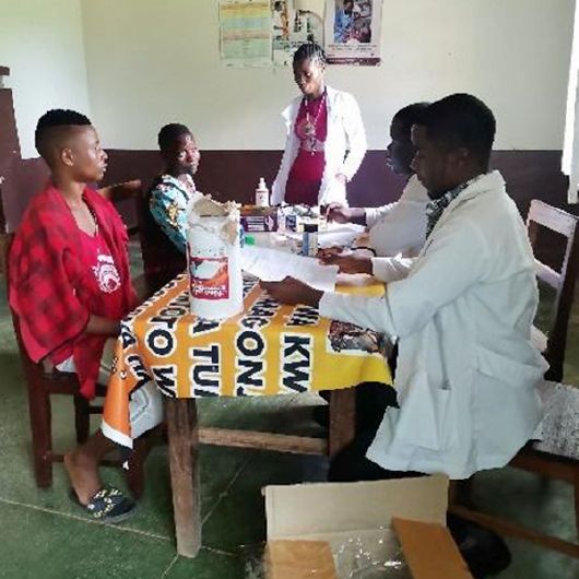 Dr. Curthbeth Seluhinga (rechts hinten) und zwei örtliche Mediziner mit Patienten in Nangombo.