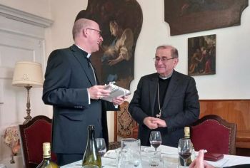 Bischof Dr. Franz Jung (links) überreichte nach der Messe beim Mittagessen dem Mailänder Erzbischof Mario Delpini das Buch, das zum Anlass des 1000. Todestags des in Würzburg geborenen heiligen Aquilin entstand. 