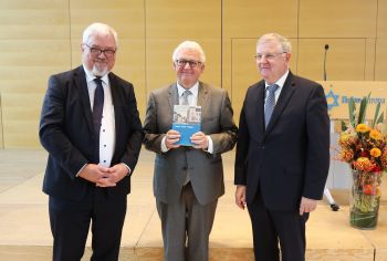 Professor Dr. Klaus Reder (Mitte) erhält aus den Händen von Professor Dr. Enno Bünz (links) und Professor en. Dr. Wolfgang Weiß (rechts) die Festschrift "Region - Kultur - Religion".