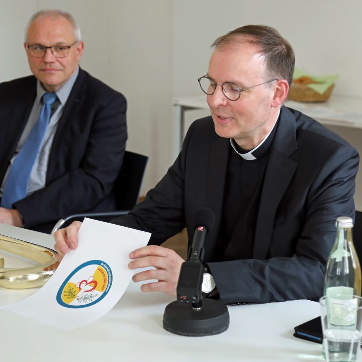 Der ernannte Weihbischof Paul Reder stellt sein Emblem vor. Links Liturgiereferent Dr. Stephan Steger.